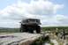 1995 Ford Bronco - A lifted Ford Bronco navigates a rocky trail with two people observing.