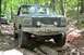 1995 Ford Bronco - This 1992 Ford Bronco is tackling a challenging rocky trail in the woods, with another Bronco following behind.