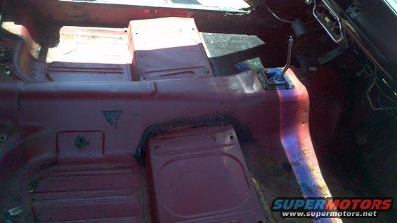 Interior floor and transmission tunnel of a red vehicle