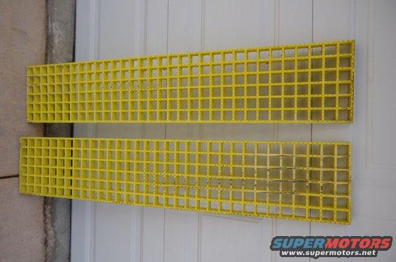 Two yellow grates with square openings, one above the other, against a white paneled background
