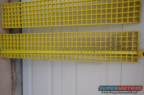Two yellow plastic grates with a tape measure on the bottom one