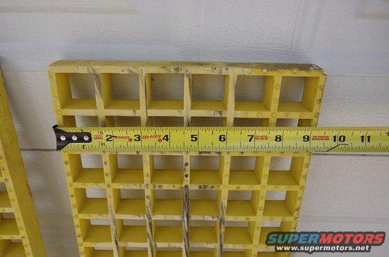 Yellow plastic grille section with a Stanley tape measure across it