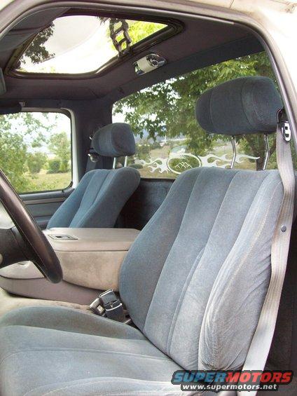 Truck interior with gray cloth seats, center console, sunroof, and flame decals on the rear window