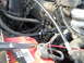 1992 Ford Bronco - Close-up view of engine components, including a red battery and various hoses.