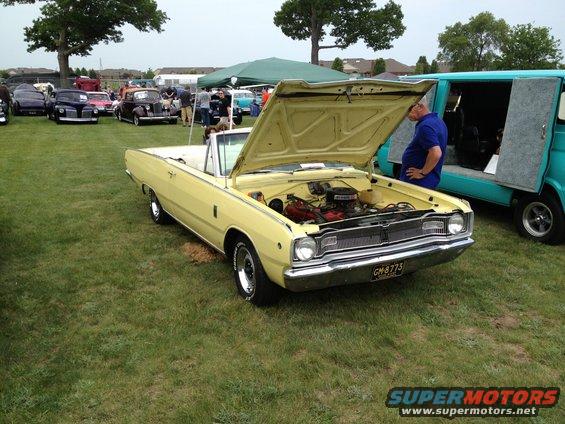 Yellow convertible with hood open, showing engine. License plate reads GM 8775
