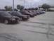2003 Ford Crown Victoria - A line of maroon 2003 Ford Crown Victorias are parked in a lot.