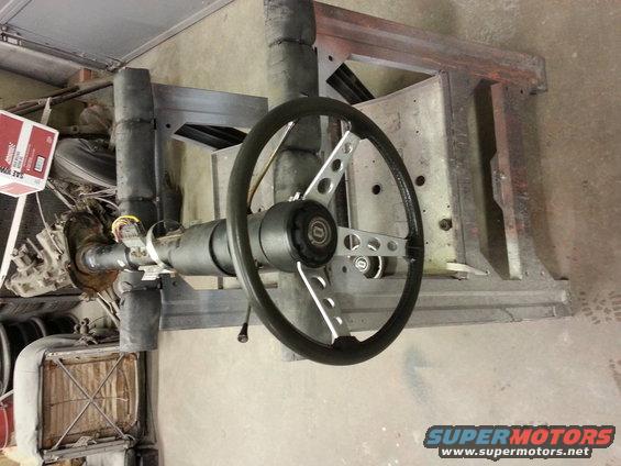 Steering column and wheel assembly, possibly aftermarket, with wiring visible