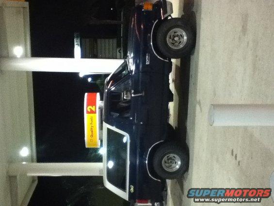 Dark blue 1988 Ford Bronco with white top parked at a gas station