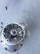 1996 Ford Probe - An aluminum automotive part, possibly a hub or cover, is shown disassembled with screws scattered around it.