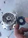 1996 Ford Probe - A disassembled wheel hub component is shown, with screws and a black gasket held by a hand.