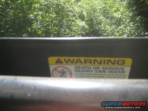 Yellow warning sticker with text about death or serious injury