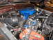 1979 Ford F-150 - The engine bay of a 1979 Ford F-150 shows a blue air cleaner assembly and a red battery.