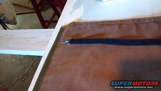 20130616_095338_148.jpg The start of the bikini top.  The green webbing goes to the front, attaching to snap studs on the body.  The black strap is sewn into the left and right sides, then hooks to eye at the rear of the rail.  Buckles and parachute clasps ensure tension and adjustability.