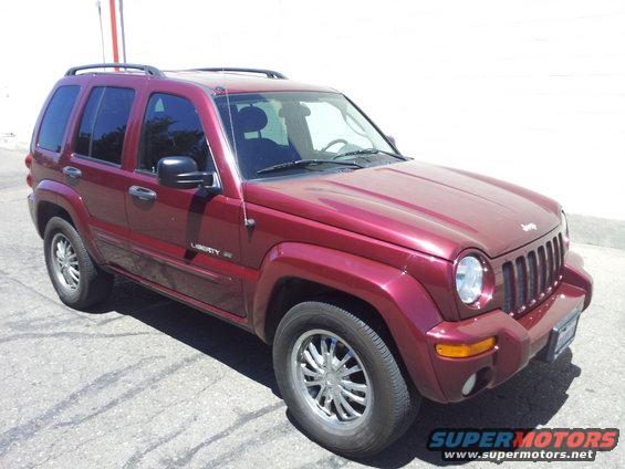 Red Jeep Liberty SUV parked on asphalt