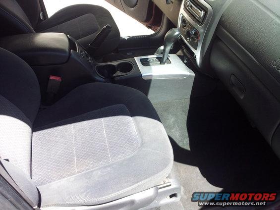 Interior view of a car, showing front seats, center console with gear shifter, and dashboard
