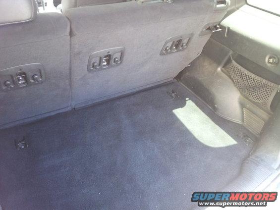Interior cargo area with dark carpet and tie-down points