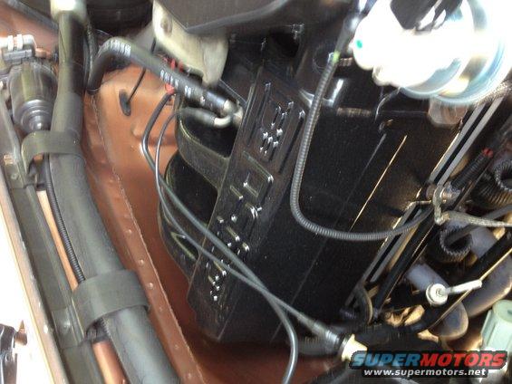 Engine bay with black plastic housing and copper tubing, viewed from above