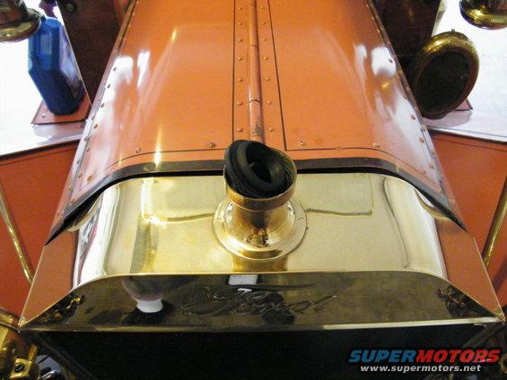 Orange hood and brass radiator of a 1912 Ford Model T with the Ford script visible