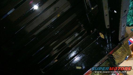 Black painted undercarriage with ribbed metal panels and visible bolts