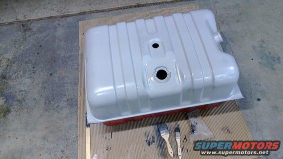 White fuel tank with red trim, two paint brushes nearby