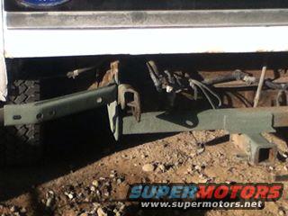White vehicle rear frame with green tow hitch and exposed wiring