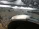 1996 Ford Bronco - Body panel of a vehicle undergoing repair, covered in body filler and primer.