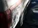1996 Ford Bronco - Bodywork is underway on the rear of a vehicle, with primer and filler applied to the damaged area.