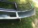 1996 Ford Bronco - A detached front bumper and brush guard assembly rests on grass.