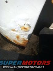 White vehicle fender with rust damage and a SuperMotors.net logo