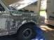 1996 Ford Bronco - This Ford Bronco is in the process of being repaired, with its hood up and bodywork visible on the fender.