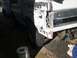 1996 Ford Bronco - Rear view of a damaged white vehicle, showing a missing taillight and dented quarter panel.