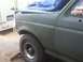 1996 Ford Bronco - 1996 Ford Bronco undergoing bodywork, showing primer gray paint on the fender and wheel well.