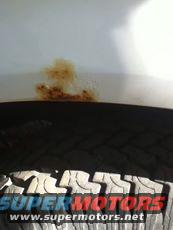 Tire with Supermotors.net text and white fender with rust stain