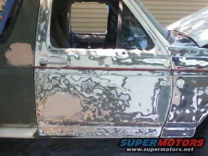 Side view of a 1996 Ford Bronco undergoing bodywork with primer and filler visible
