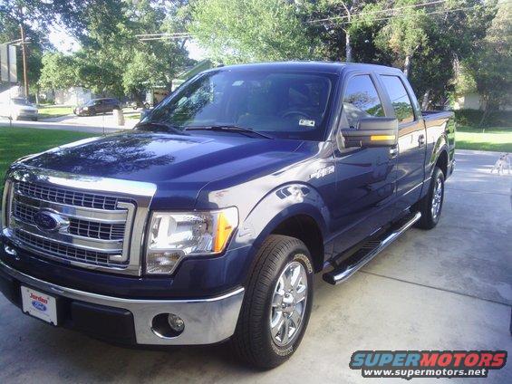 Blue 2013 Ford F-150 parked in driveway, front 3/4 view