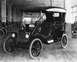 1909 Ford Model T - A black 1909 Ford Model T touring car is parked indoors, with a line of similar vehicles in the background.