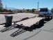 2001 Ford Mustang - A blue Ford pickup truck is loaded onto a trailer, with its camper shell's rear hatch open.