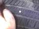 2003 Ford Crown Victoria - A nail is lodged in the tire tread, indicating a puncture.