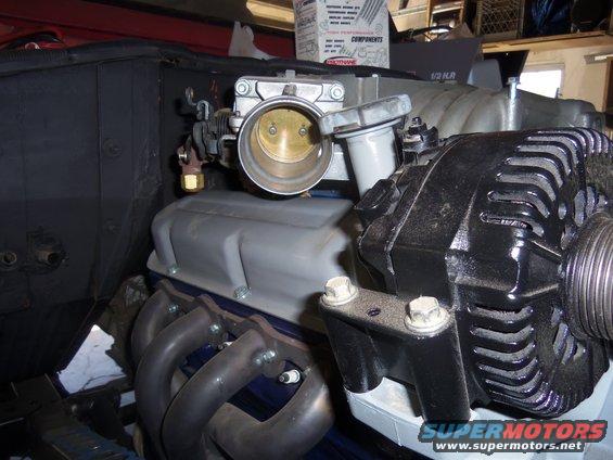 Engine components: alternator, throttle body, and exhaust manifold