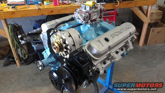 Pontiac V8 engine on a stand, with a carburetor and alternator visible