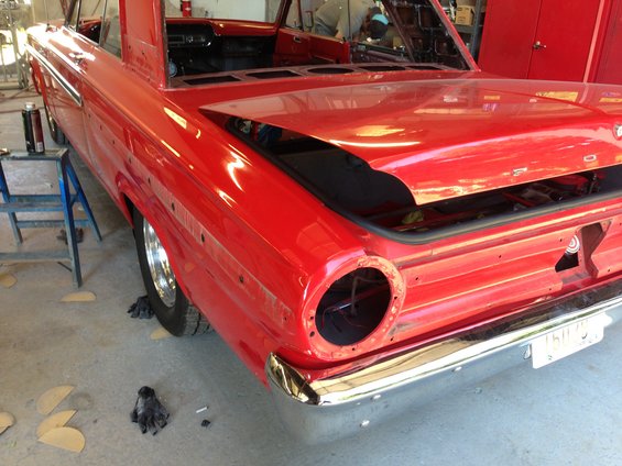 1964 Ford Fairlane rear end in garage, undergoing restoration with trunk open and taillights removed