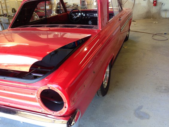 1964 Ford Fairlane in a garage, rear view, hood open, missing taillights
