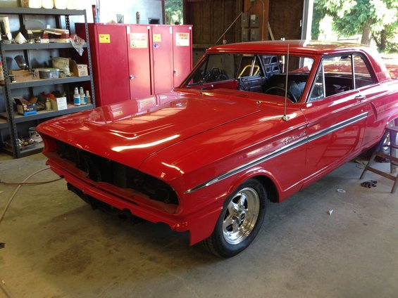 Red 1964 Ford Fairlane coupe with chrome trim and aftermarket wheels
