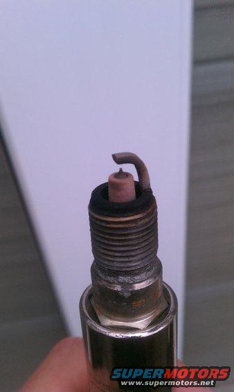 Close-up of a used spark plug with a bent electrode