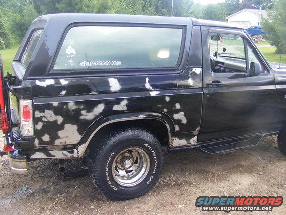 Black Ford Bronco with peeling paint and a spare tire on the rear