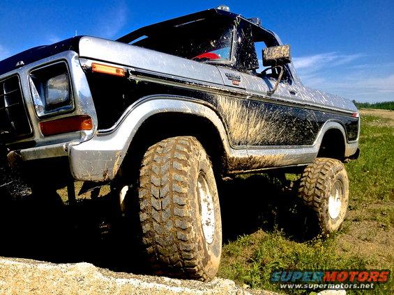 Mud-splattered 1979 Ford Bronco, 3/4 front view, two-tone black and silver