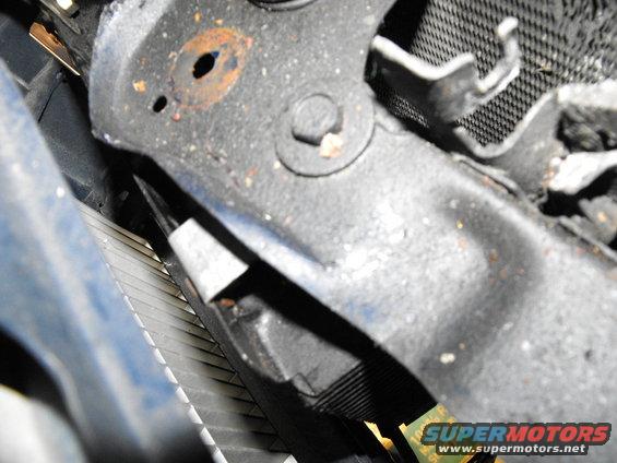 dscf2586.jpg Here's the driver's side top corner of the cooler being supported by a 90 degree bracket "nutted" to a bolt that holds on the hood latch. 