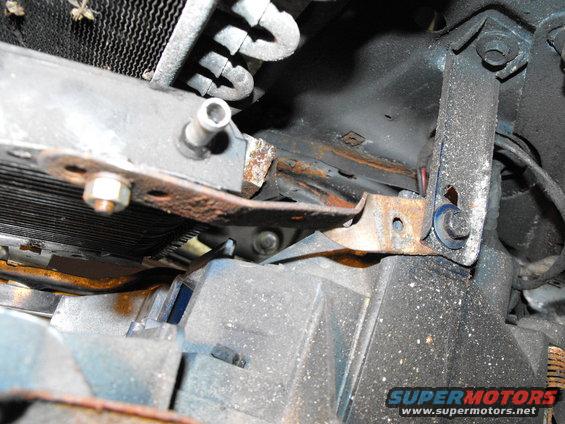 dscf2604.jpg Last mount was the passenger's side lower bracket. I simply twisted strap steel 90 degrees allowing it be bolted to the bottom of one of the plastic headlight buckets using one of the stock bucket bolts. Cooler fully secured in four places, centered in the wind stream of the grill and plenty of access to the pipe nipples to get the hoses and clamps on.