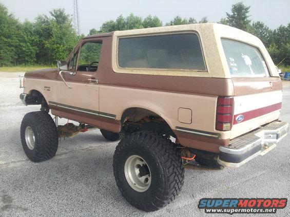 Lifted 1987 Ford Bronco, two-tone brown and tan, with large off-road tires