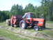 2000 Chevrolet Tahoe - Tractor and baler working in a field.
